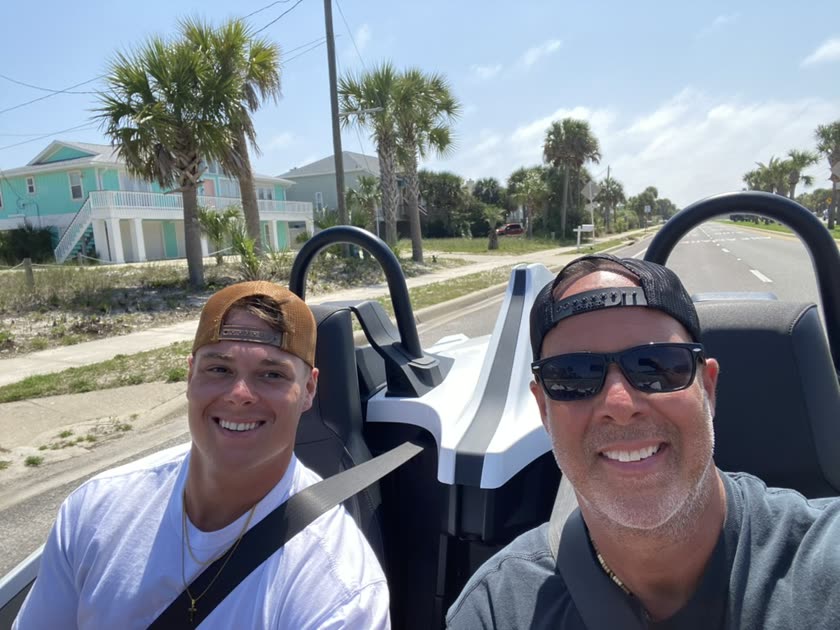 Ashby and his dad in a Slingshot on a beach road